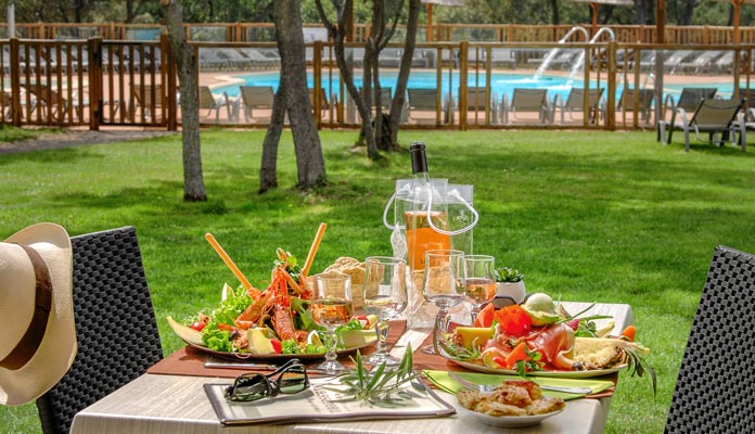 Déjeuner en terrasse au bord de la piscine du camping le Domaine de Massereau proche de Nîmes et Montpellier