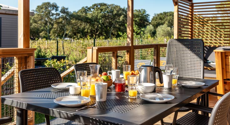 Petit déjeuner sur la terrasse du mobil-home premium au camping 5 étoiles Domaine de Massereau dans le Gard