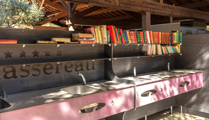 Lavabos de l'espace sanitaire d'été avec sa bibliothèque partagée au camping du Domaine de Massereau